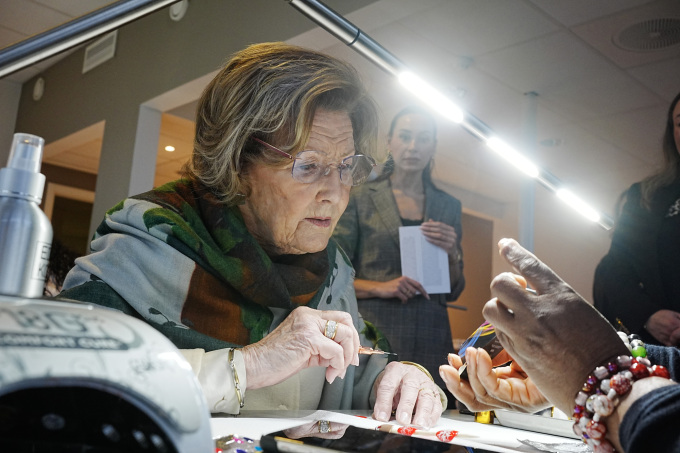 Dronning Sonja fikk selv prøve seg på negledesign sammen med en av studentene. Foto: Terje Pedersen / NTB